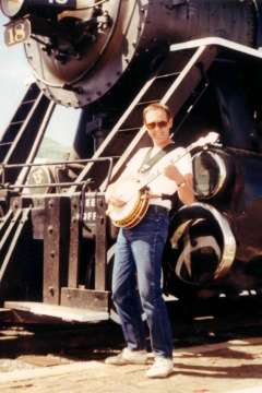 Paul Playing Banjo in front of Train